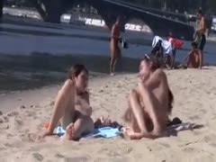 Together, the long-haired, bare-chested brunettes enjoyed the nudist beach.